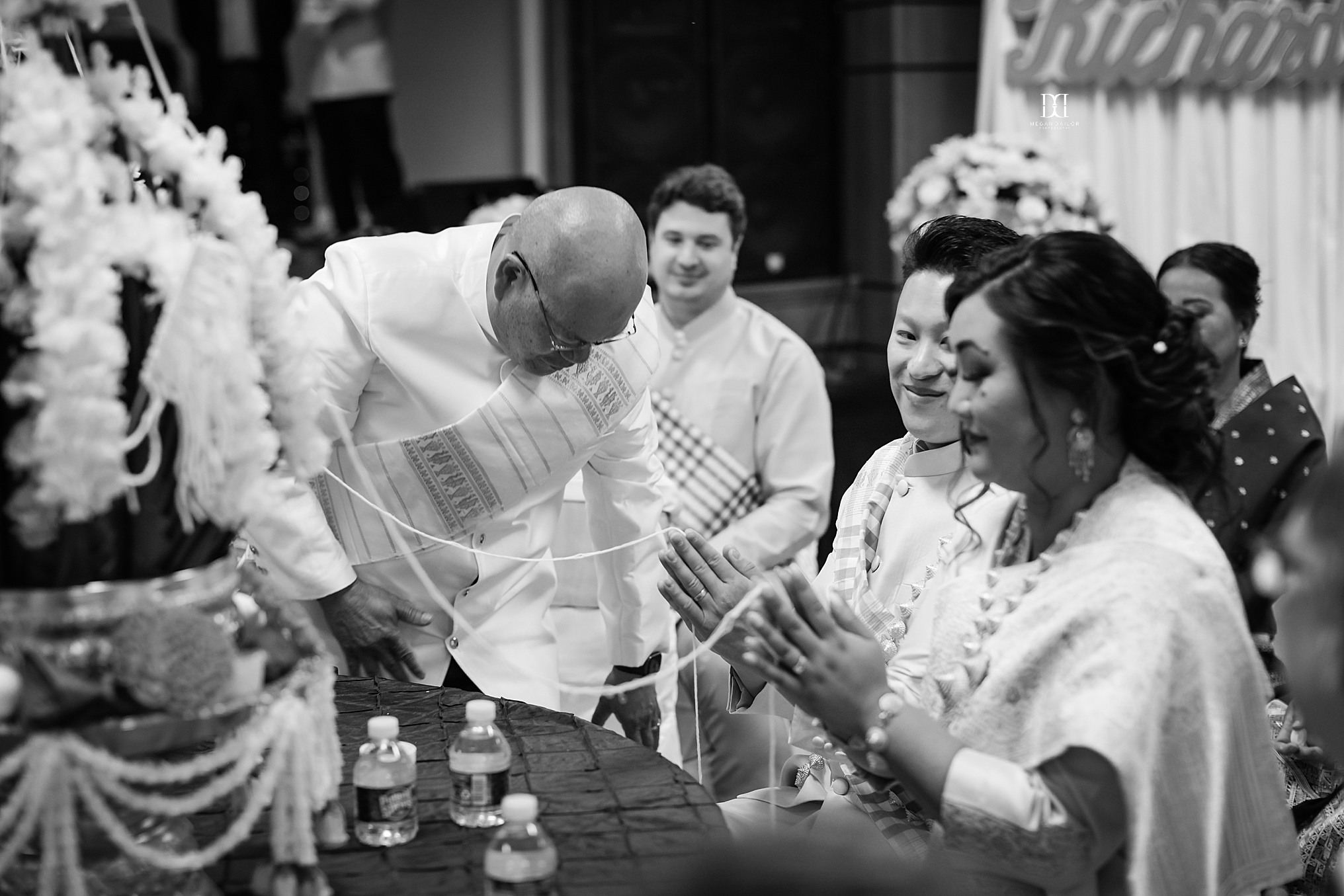 bride and groom in prayer during Lao wedding ceremony rochester photographers