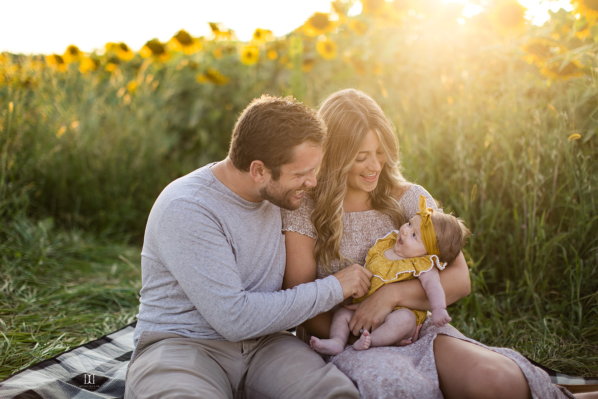 sunflower family photos in rochester mom dad and baby snuggling 